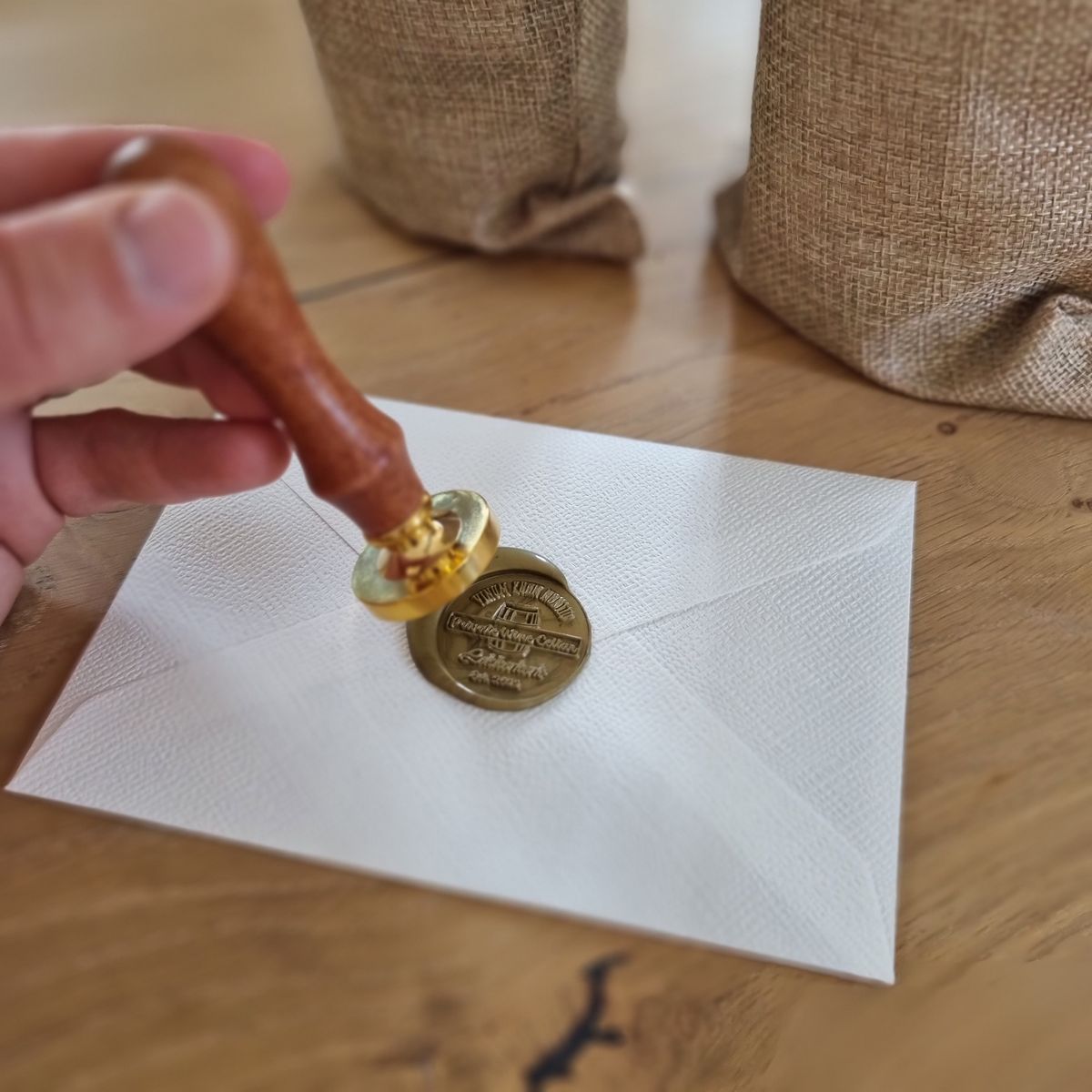 Waxzegel wordt met de gouden stempel op de envelop gedrukt