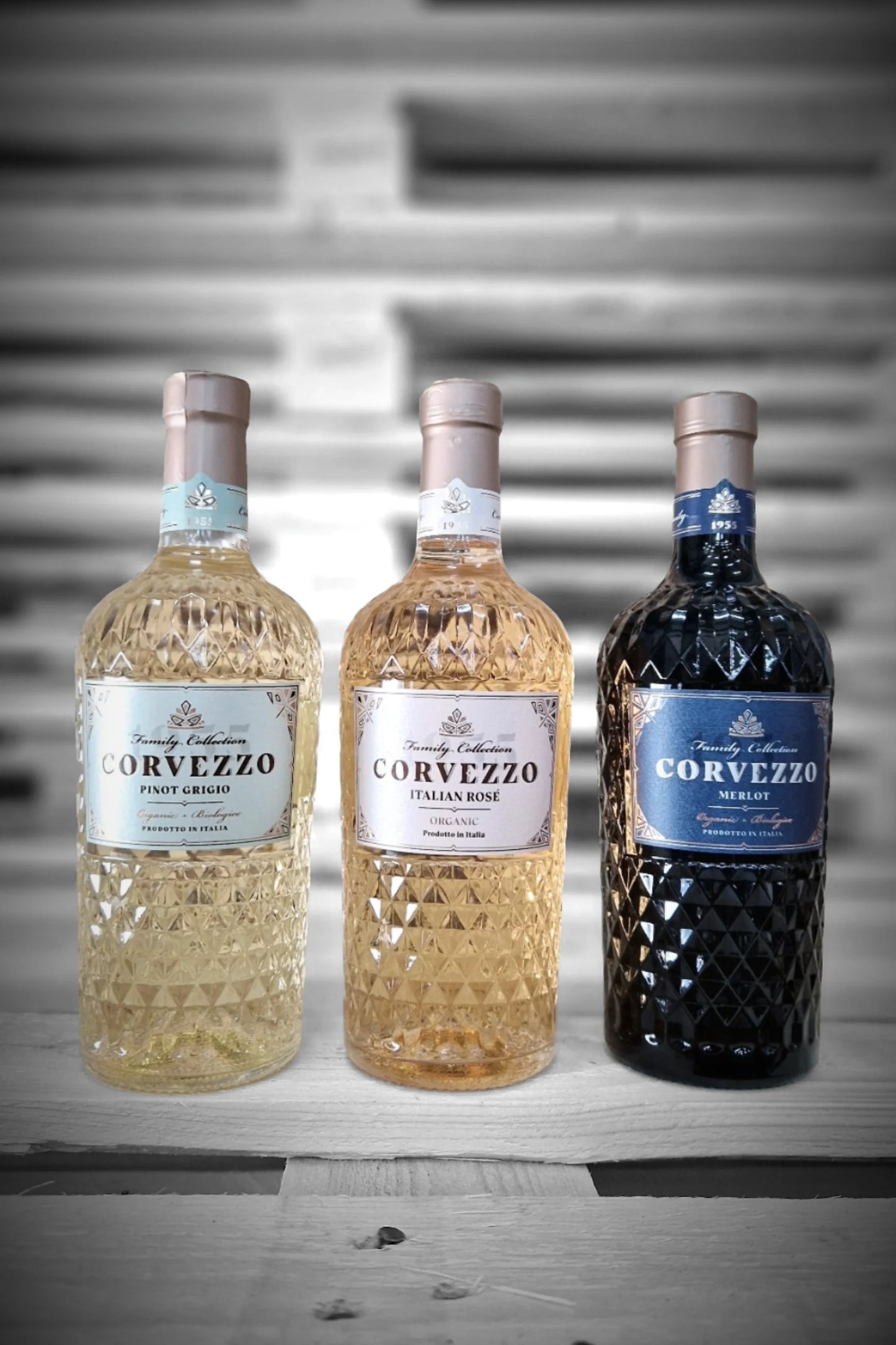 Twee flessen Corvezzo Pinot Grigio, twee Rosé en twee Merlot tegen vervaagde achtergrond – Mixdoos G (2× PG, 2× Rosé, 2× Merlot)