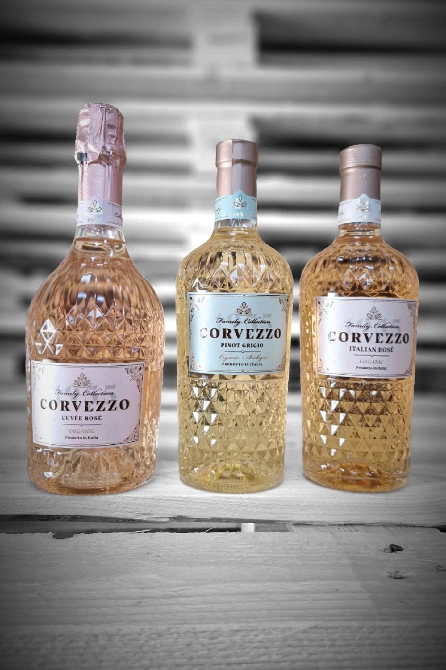 Twee flessen Corvezzo Rosé Bubbel, twee Pinot Grigio en twee Rosé tegen vervaagde achtergrond – Mixdoos H (2× Bubbel, 2× PG, 2× Rosé)